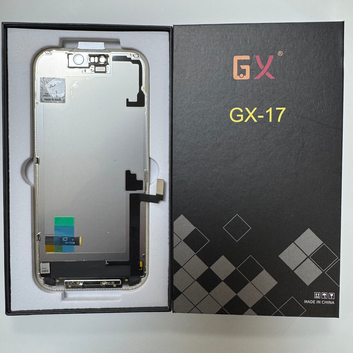 Hard OLED screen for iPhone 17 in its tray, beside its labelled box